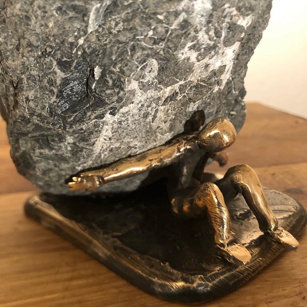 Kleine Bronzefigur Sisyphus auf Naturstein
